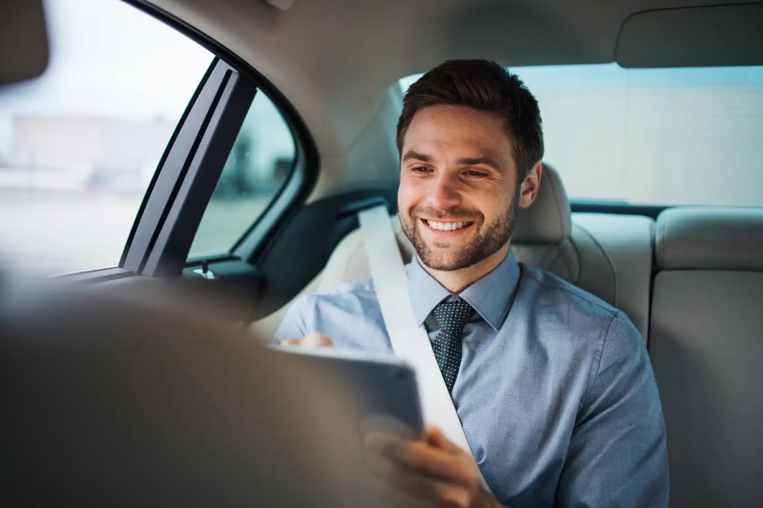 businessman with tablet sitting on back seats
